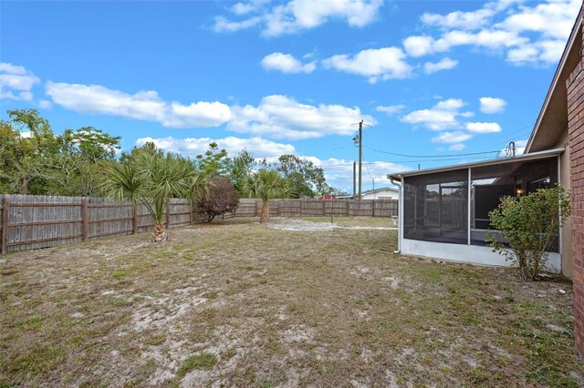 view of yard featuring a fenced backyard and a sunroom