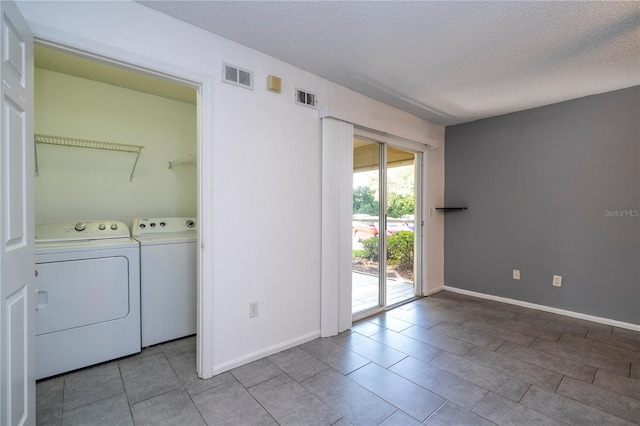 5136 Park Central Dr Unit 212, Orlando, FL 32839 - washroom featuring washing machine and clothes dryer, a textured ceiling, and visible vents