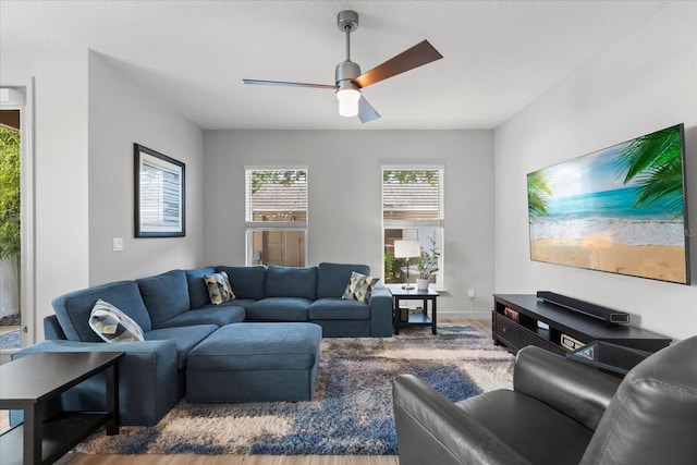 living room featuring wood finished floors, a ceiling fan, and baseboards