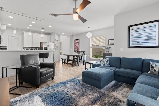 living room featuring recessed lighting, light wood-type flooring, and ceiling fan