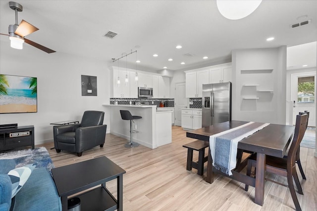 living room featuring recessed lighting, visible vents, and light wood finished floors