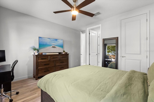 bedroom with baseboards, light wood-style flooring, visible vents, and ceiling fan