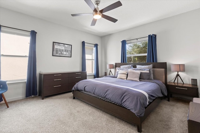 bedroom with a ceiling fan and light colored carpet