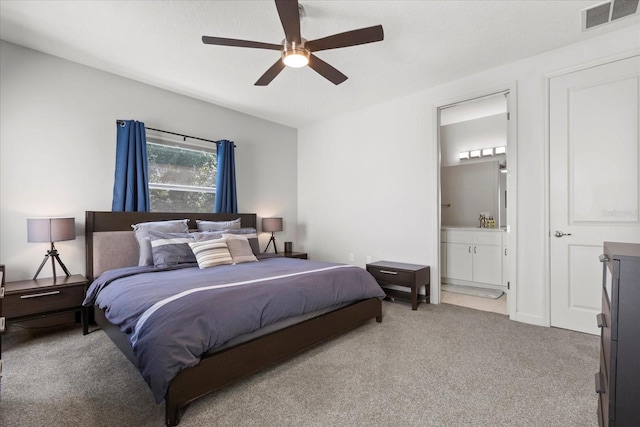 carpeted bedroom featuring ensuite bath, a ceiling fan, and visible vents