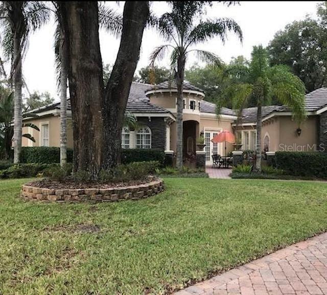 view of front of house featuring a front yard, a patio, and stucco siding