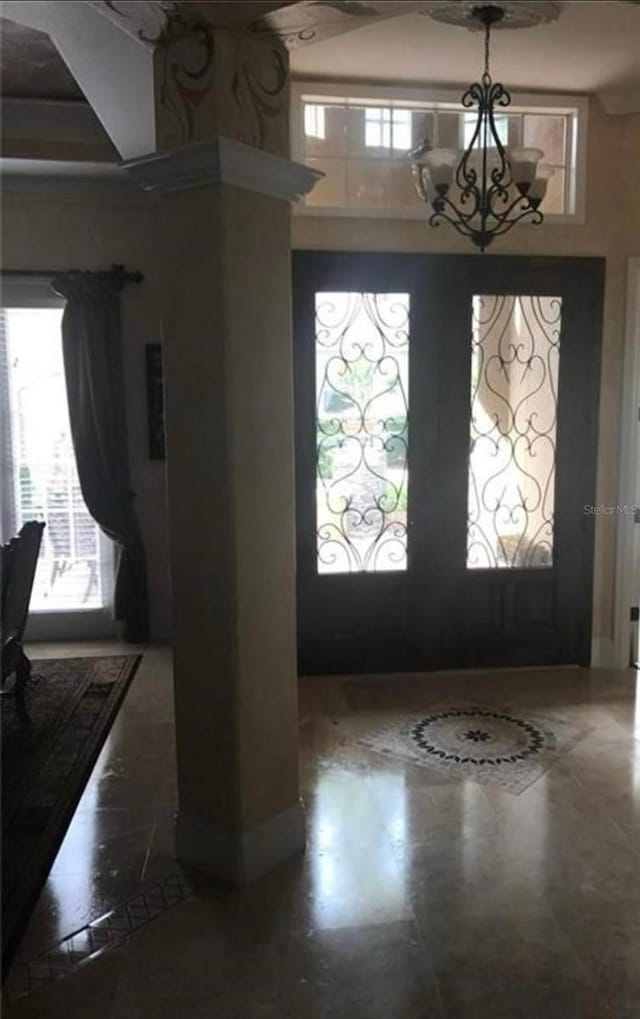 foyer featuring an inviting chandelier and a towering ceiling