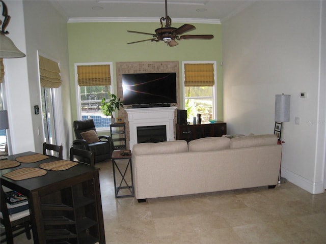 living area featuring a wealth of natural light, ornamental molding, and ceiling fan
