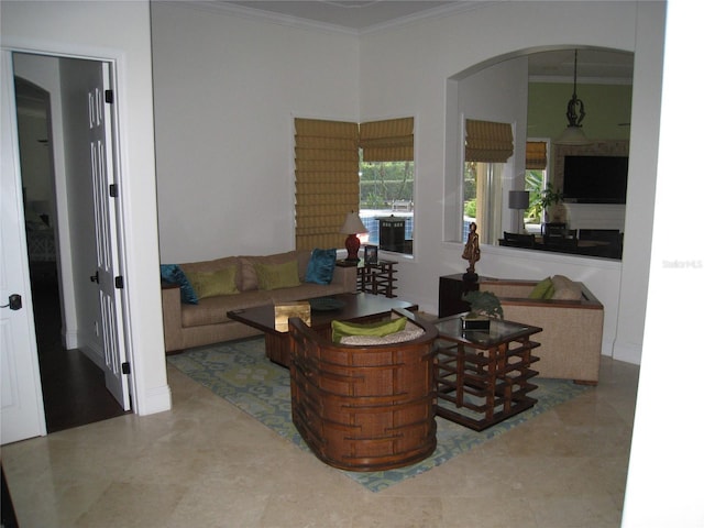 living area with crown molding and arched walkways