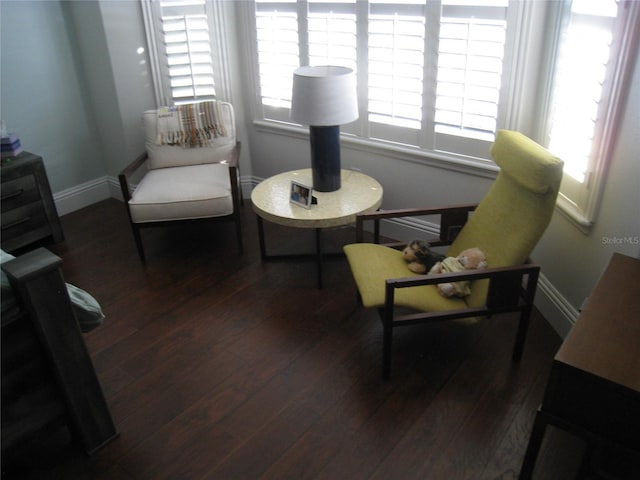 living area with baseboards and wood finished floors