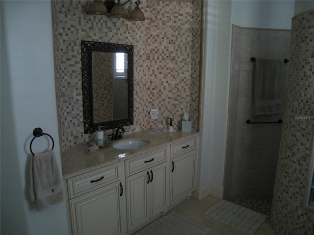 bathroom featuring tile patterned floors, vanity, and a walk in shower
