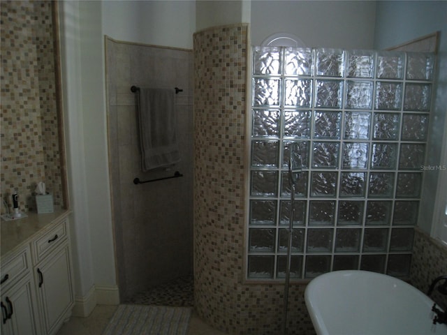 full bathroom with walk in shower, a freestanding bath, and tile patterned flooring