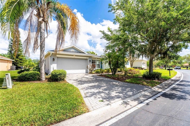 151 Bell Tower Xing W, Kissimmee, FL 34759 - view of front facade with stucco siding, a garage, decorative driveway, a front lawn, and central AC