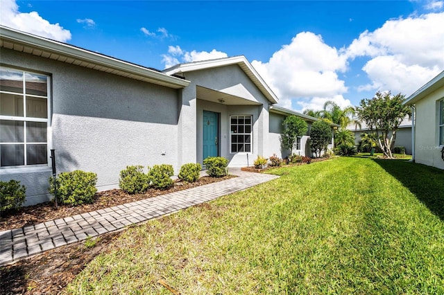 151 Bell Tower Xing W, Kissimmee, FL 34759 - doorway to property with a yard and stucco siding