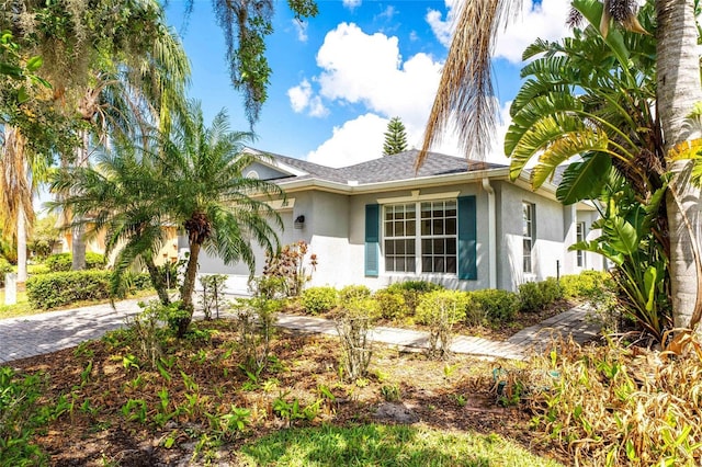 151 Bell Tower Xing W, Kissimmee, FL 34759 - view of front of home with stucco siding, an attached garage, and driveway