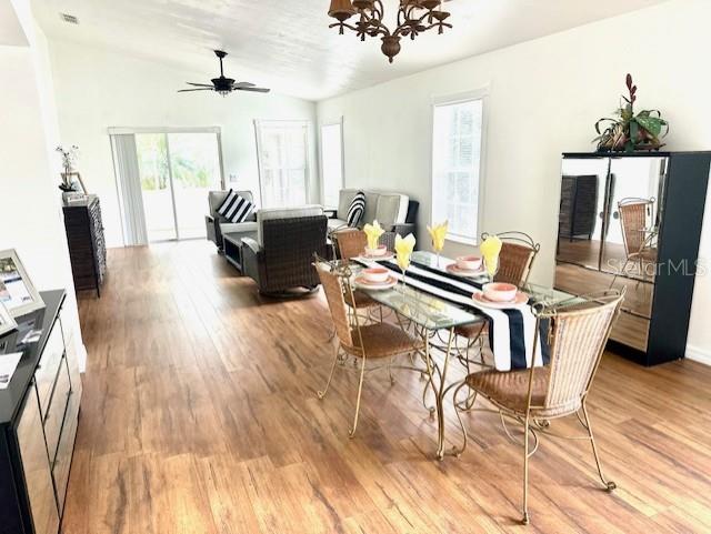 151 Bell Tower Xing W, Kissimmee, FL 34759 - dining space with light wood-style floors, a chandelier, vaulted ceiling, and ceiling fan