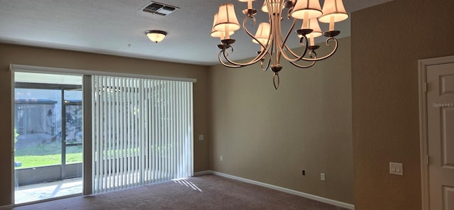 carpeted spare room with baseboards, visible vents, a textured ceiling, and a chandelier