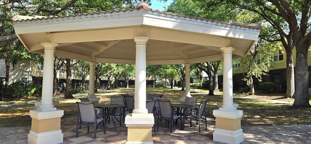 view of community with outdoor dining area, a gazebo, and a patio