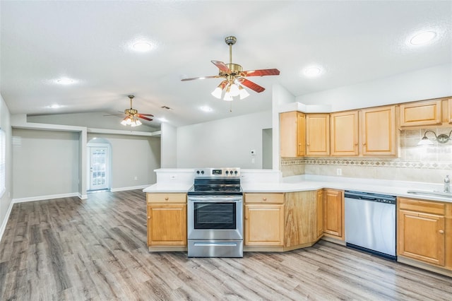 kitchen featuring light countertops, appliances with stainless steel finishes, a ceiling fan, light wood-style floors, and vaulted ceiling