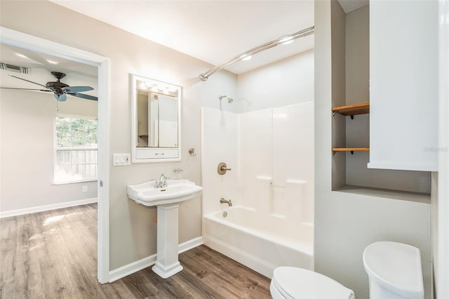 bathroom with  shower combination, toilet, visible vents, ceiling fan, and wood finished floors