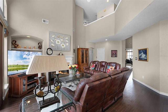 3033 Zaharias Dr, Orlando, FL 32837 - living room with dark wood-type flooring, baseboards, a glass covered fireplace, and visible vents