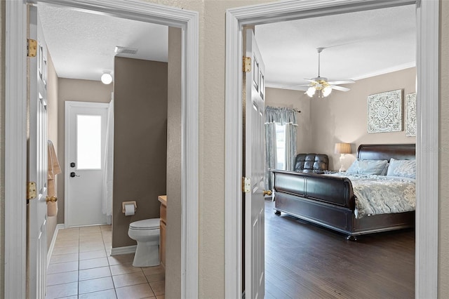 3033 Zaharias Dr, Orlando, FL 32837 - bedroom with visible vents, baseboards, a ceiling fan, a textured ceiling, and wood finished floors