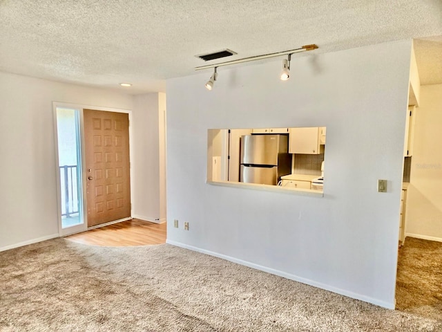 5 Buck Cir # B5, Haines City, FL 33844 - unfurnished living room with carpet flooring, visible vents, a textured ceiling, and track lighting