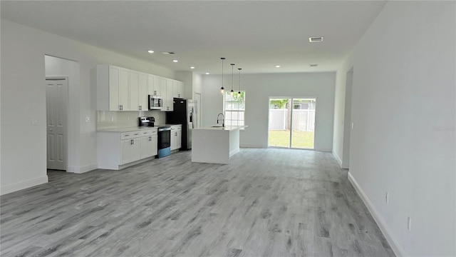 699 Marion Oaks Trl, Ocala, FL 34473 - unfurnished living room with baseboards, recessed lighting, visible vents, light wood finished floors, and a sink