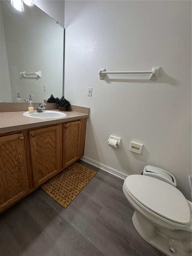 1119 Park Ridge Cir, Kissimmee, FL 34746 - half bathroom with toilet, wood finished floors, baseboards, and vanity
