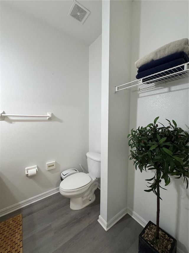 1119 Park Ridge Cir, Kissimmee, FL 34746 - bathroom with baseboards, visible vents, wood finished floors, and toilet