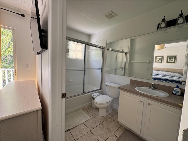 1119 Park Ridge Cir, Kissimmee, FL 34746 - full bathroom with toilet, vanity, tile patterned flooring, visible vents, and shower / bath combination with glass door