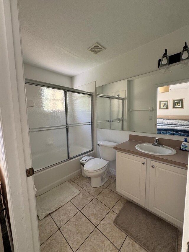 1119 Park Ridge Cir, Kissimmee, FL 34746 - ensuite bathroom with visible vents, toilet, tile patterned floors, vanity, and enclosed tub / shower combo