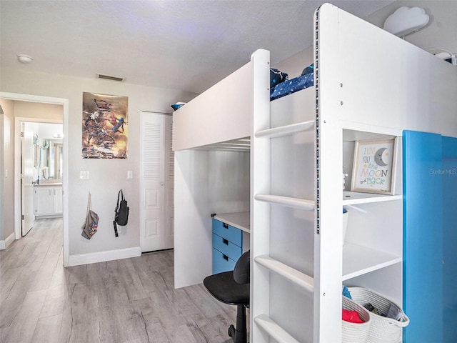 interior space with wood finished floors, visible vents, and baseboards