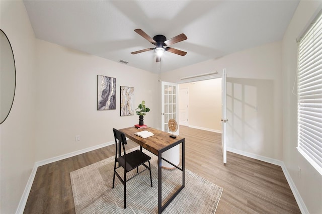home office featuring baseboards, french doors, visible vents, ceiling fan, and wood finished floors