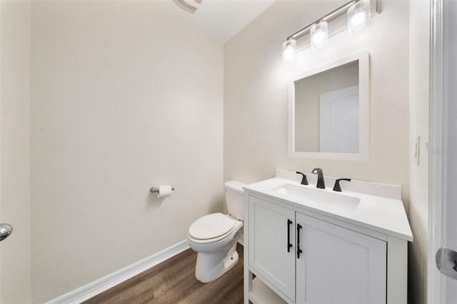 bathroom featuring vanity, baseboards, toilet, and wood finished floors