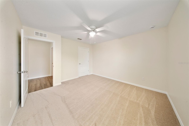 unfurnished room featuring carpet flooring, visible vents, baseboards, and a ceiling fan