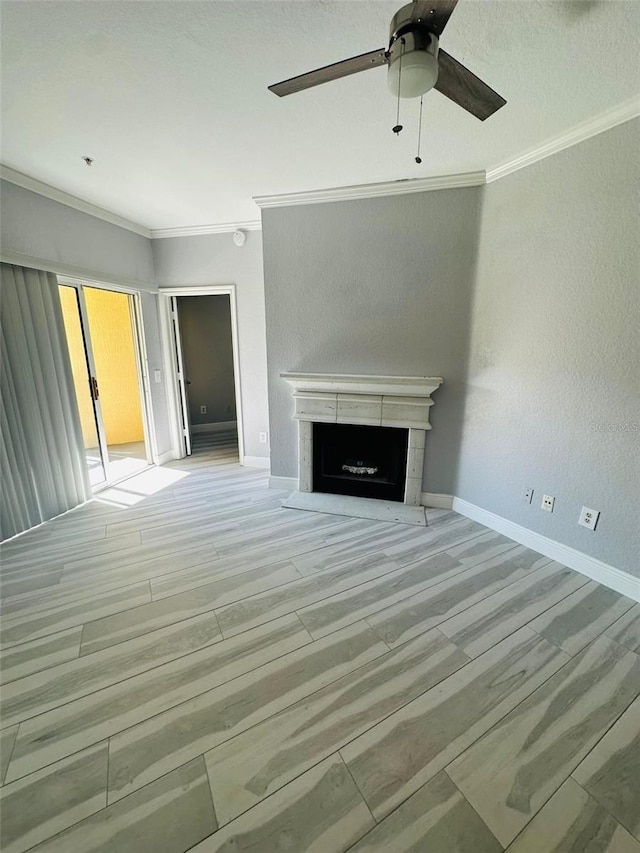 unfurnished living room with baseboards, ornamental molding, a ceiling fan, a fireplace, and light wood-style flooring