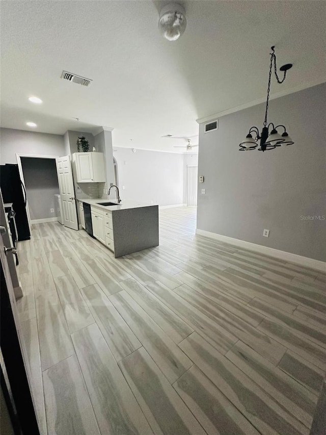 kitchen with visible vents, black dishwasher, a sink, open floor plan, and light wood finished floors