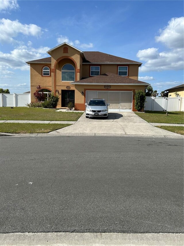 5406 Crepe Myrtle Cir, Kissimmee, FL 34758 - view of front of home with fence, stucco siding, driveway, and a front lawn