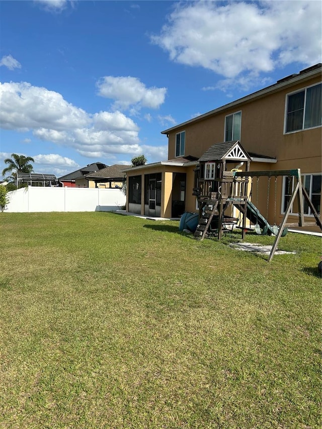 5406 Crepe Myrtle Cir, Kissimmee, FL 34758 - view of yard featuring a sunroom, fence, and a playground