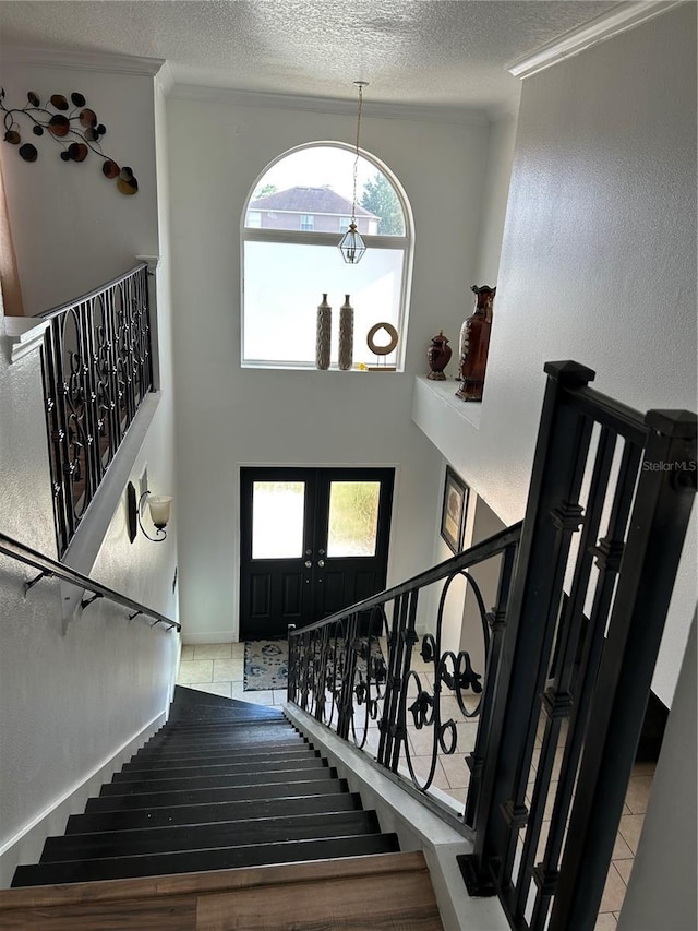 5406 Crepe Myrtle Cir, Kissimmee, FL 34758 - staircase with tile patterned floors, a high ceiling, and a textured ceiling