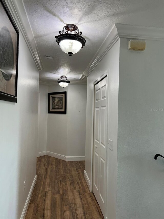 5406 Crepe Myrtle Cir, Kissimmee, FL 34758 - hall with a textured ceiling, dark wood-style floors, baseboards, and ornamental molding