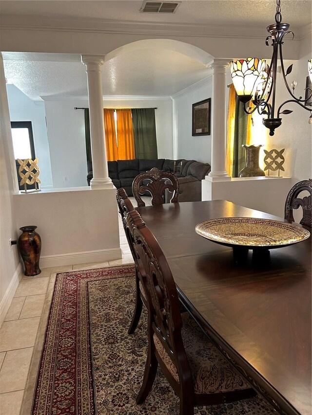 5406 Crepe Myrtle Cir, Kissimmee, FL 34758 - tiled dining space featuring visible vents, baseboards, ornate columns, a textured ceiling, and arched walkways