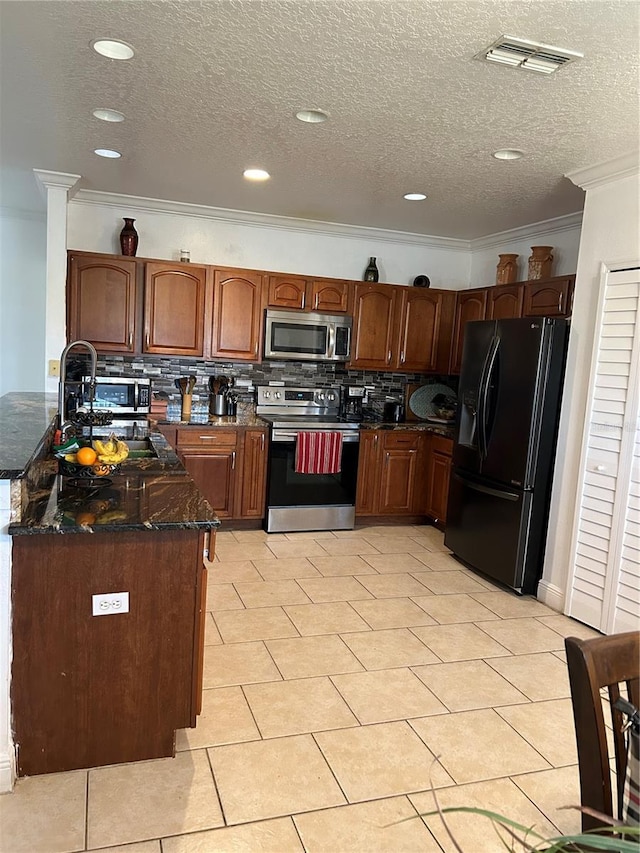 5406 Crepe Myrtle Cir, Kissimmee, FL 34758 - kitchen featuring visible vents, decorative backsplash, crown molding, dark stone countertops, and stainless steel appliances