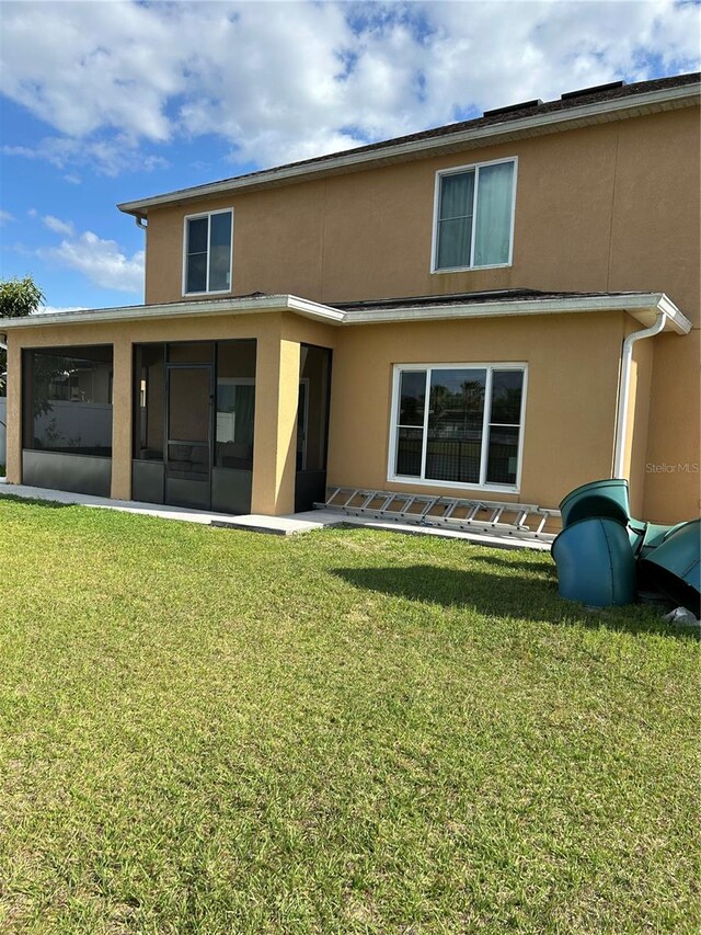 5406 Crepe Myrtle Cir, Kissimmee, FL 34758 - rear view of house featuring a sunroom, stucco siding, and a yard