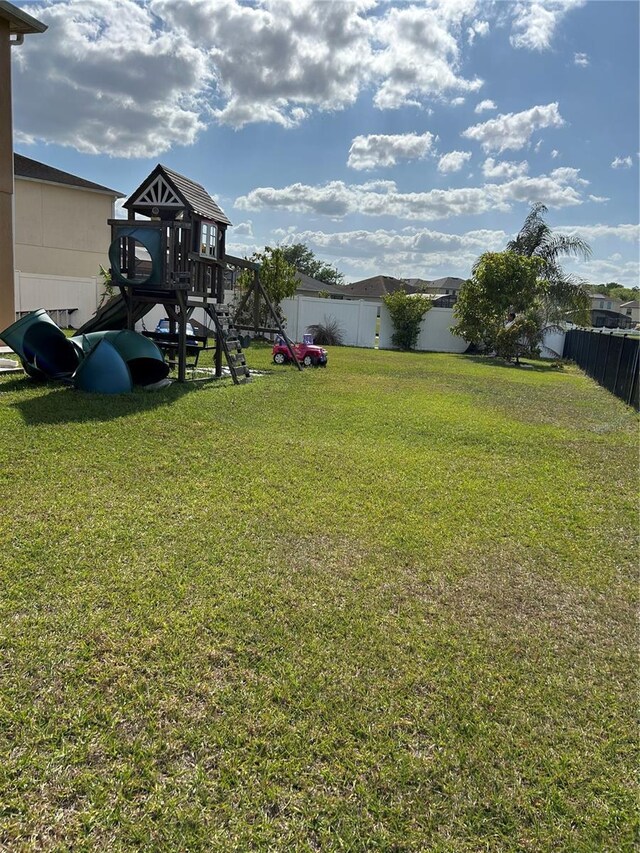 5406 Crepe Myrtle Cir, Kissimmee, FL 34758 - view of yard featuring a fenced backyard and a playground
