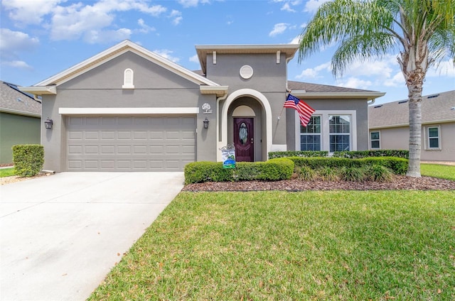 mediterranean / spanish home with stucco siding, an attached garage, driveway, and a front yard