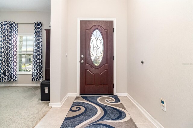 entryway featuring baseboards and light tile patterned flooring