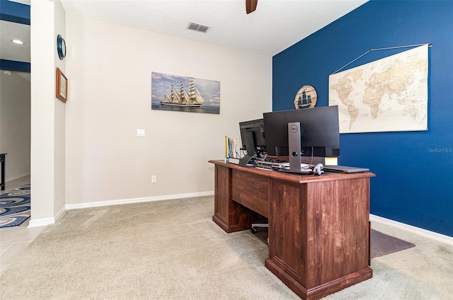 office space featuring carpet floors, visible vents, a ceiling fan, and baseboards