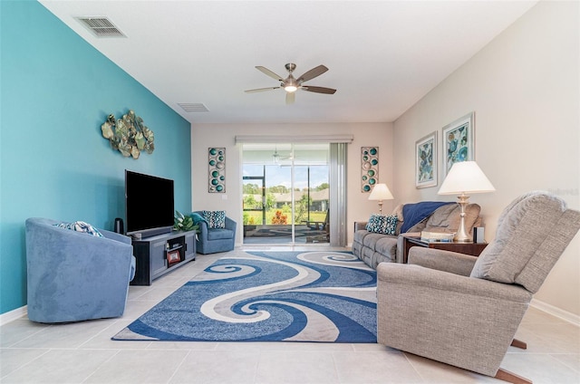 tiled living area with baseboards, visible vents, and ceiling fan