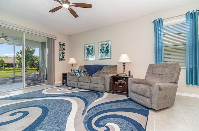 living area with baseboards, a ceiling fan, and tile patterned floors